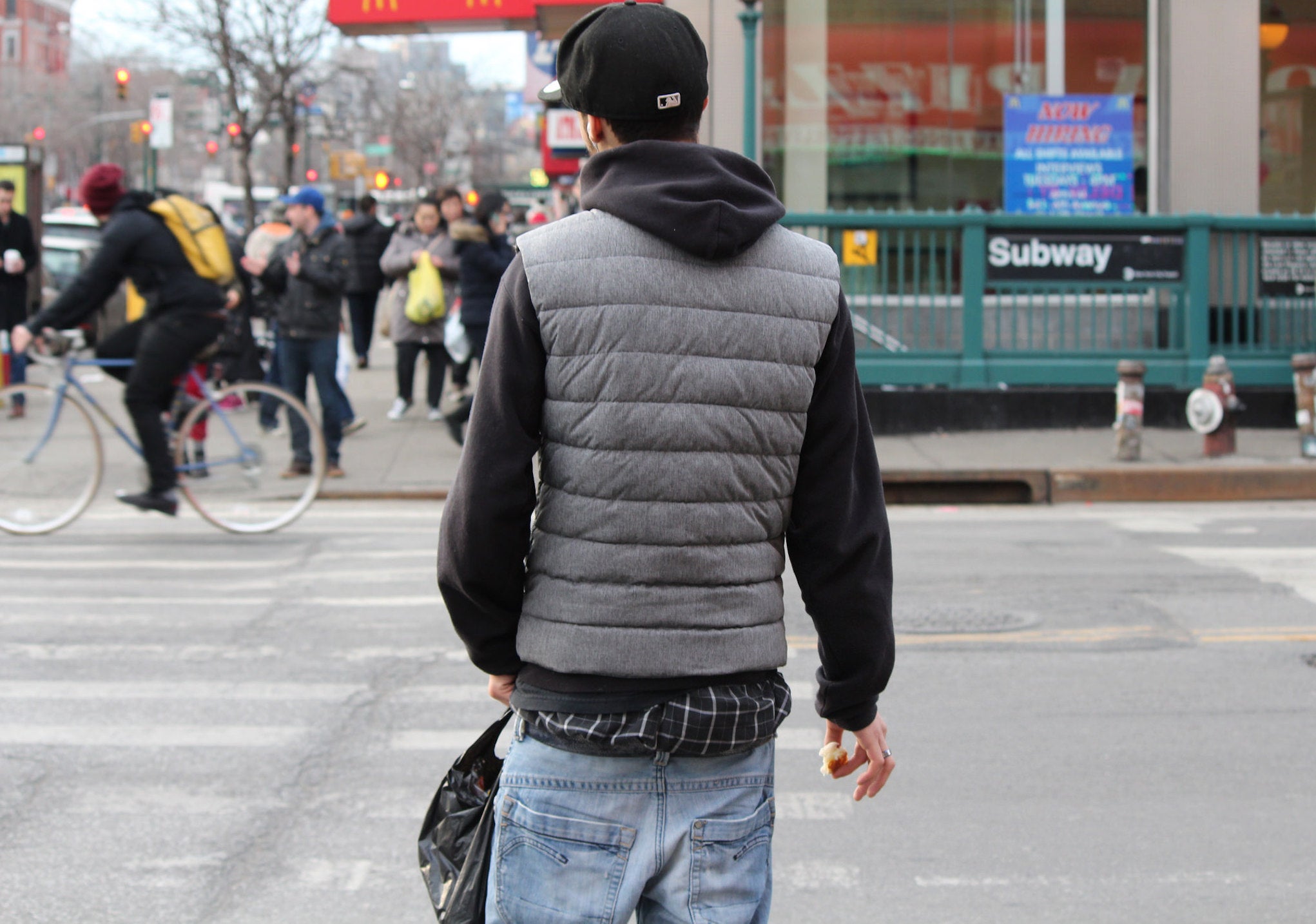 A young man walks across the street.