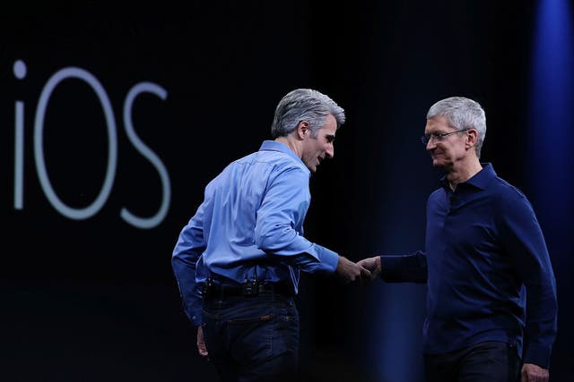 Apple senior vice president of Software Engineering, Craig Federighi (L), shakes hands with Apple CEO Tim Cook during the Apple WWDC on June 8, 2015 in San Francisco, California