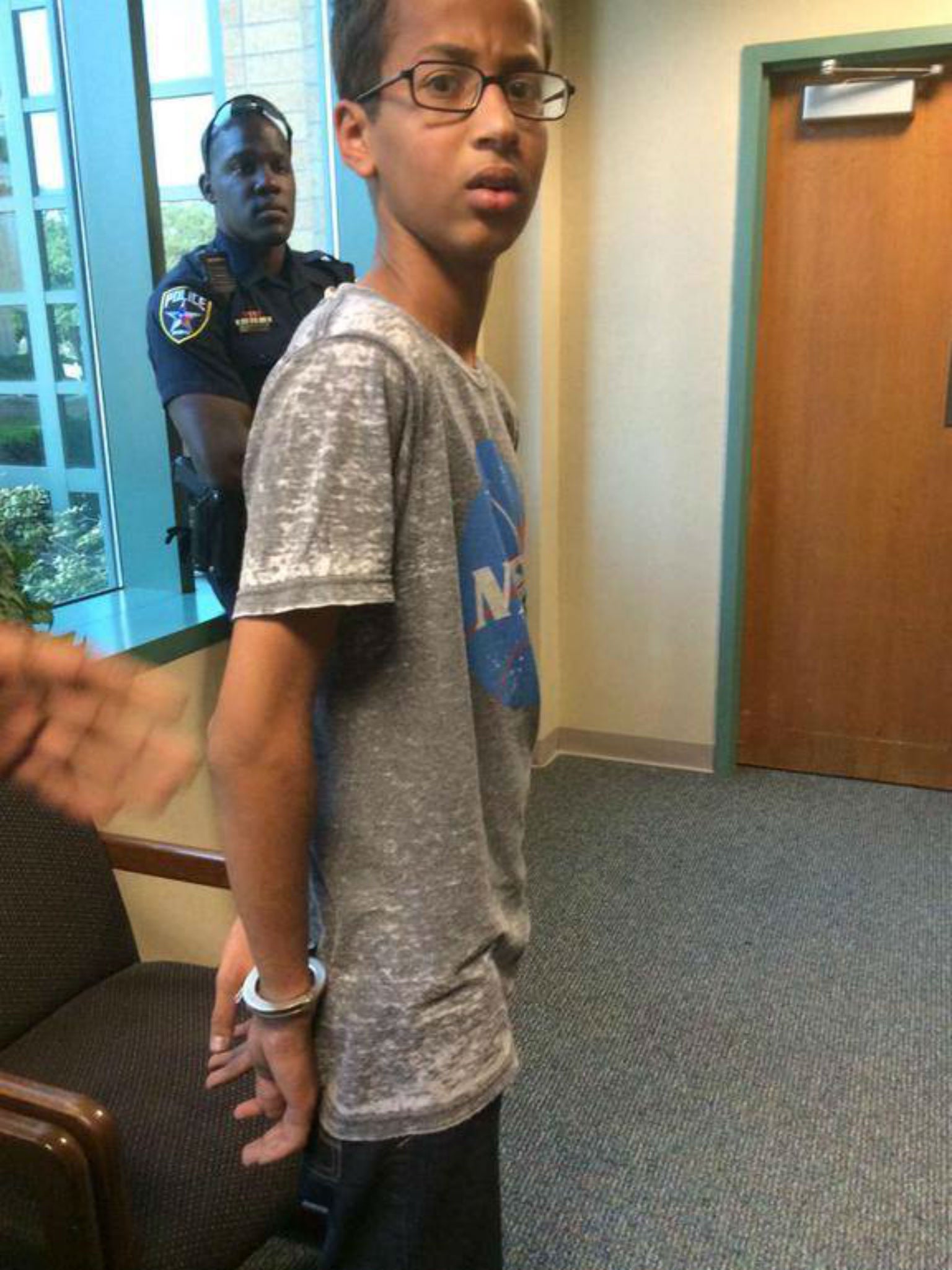 Ahmed being led away in handcuffs