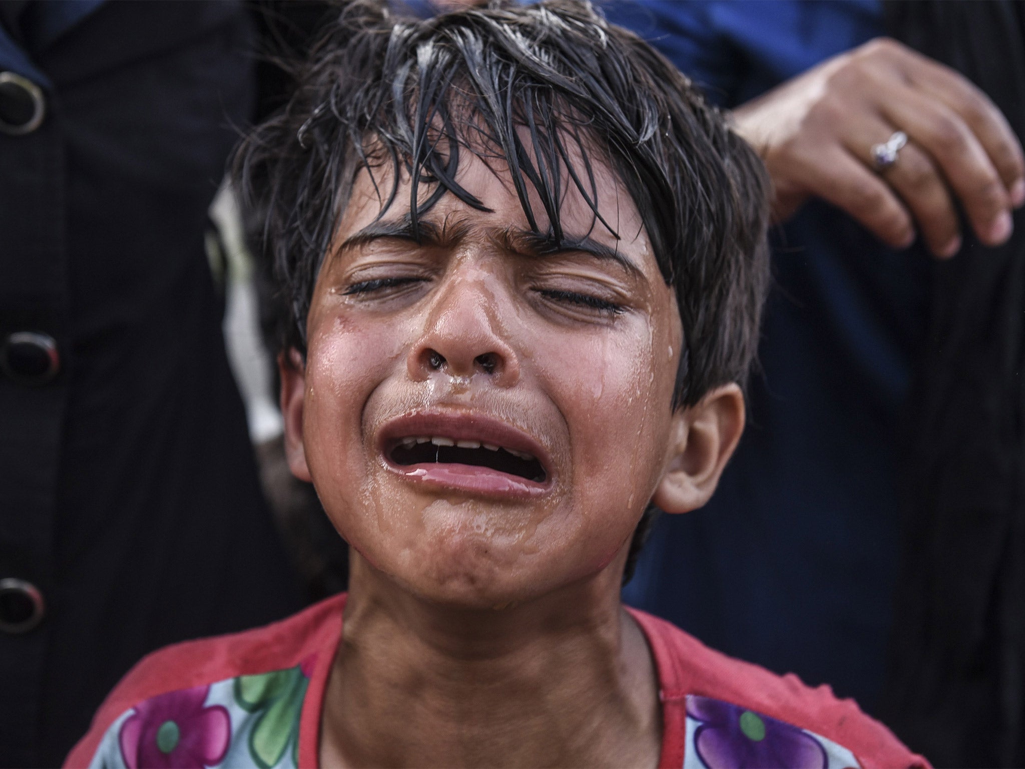 A child cries after police fired tear gas to disperse the refugees (Getty)