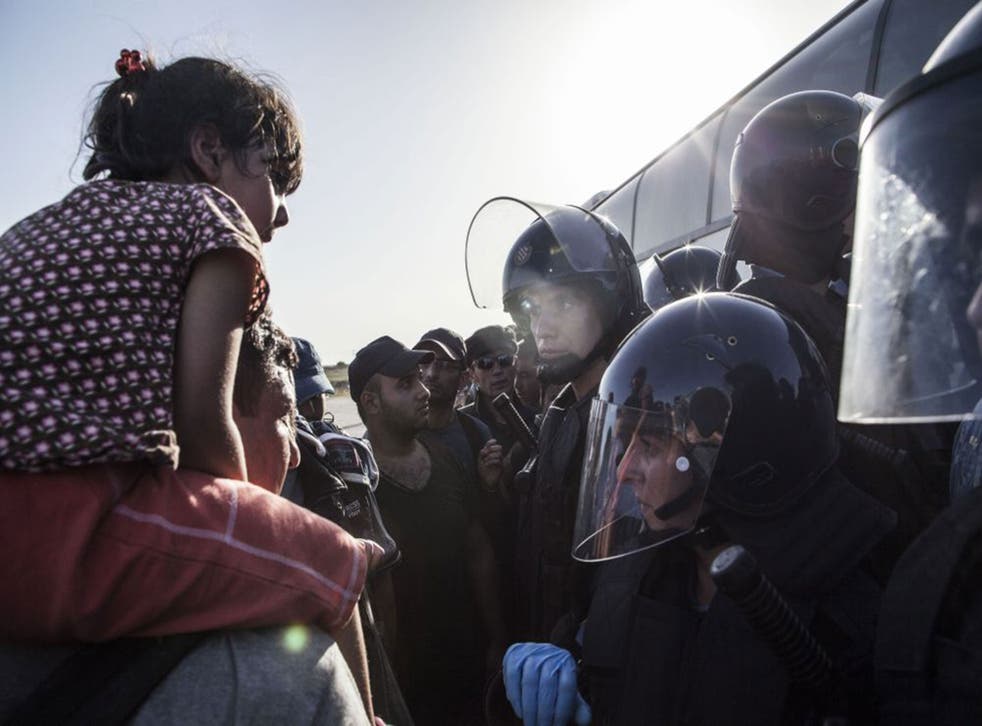 Migrants are prevented from boarding a bus by riot police, at the border between Serbia and Croatia, in Tovarnik, Croatia
