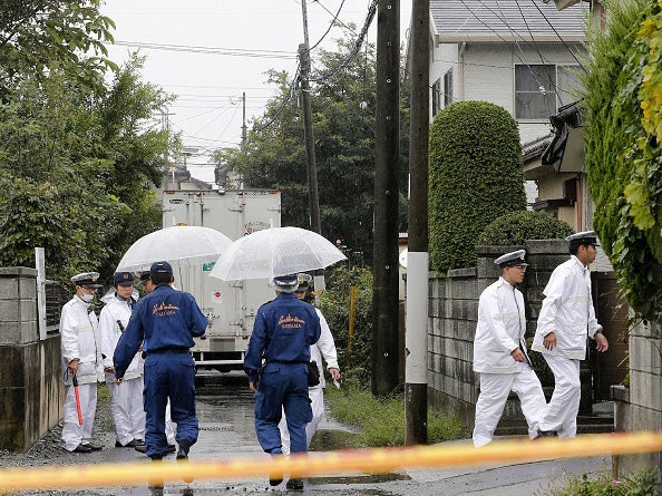 Policemen investigate the area around the murder scene in Kumagaya, Saitama prefecture on September 17, 2015 where six people were found stabbed to death