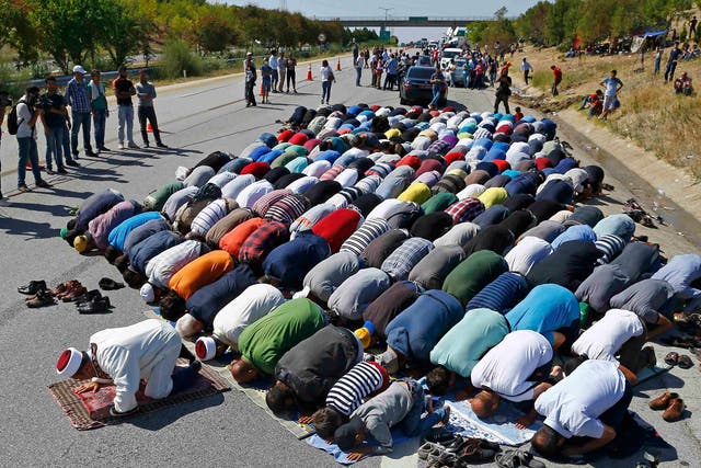 Refugees stop to pray near Edirne, Turkey, yesterday
