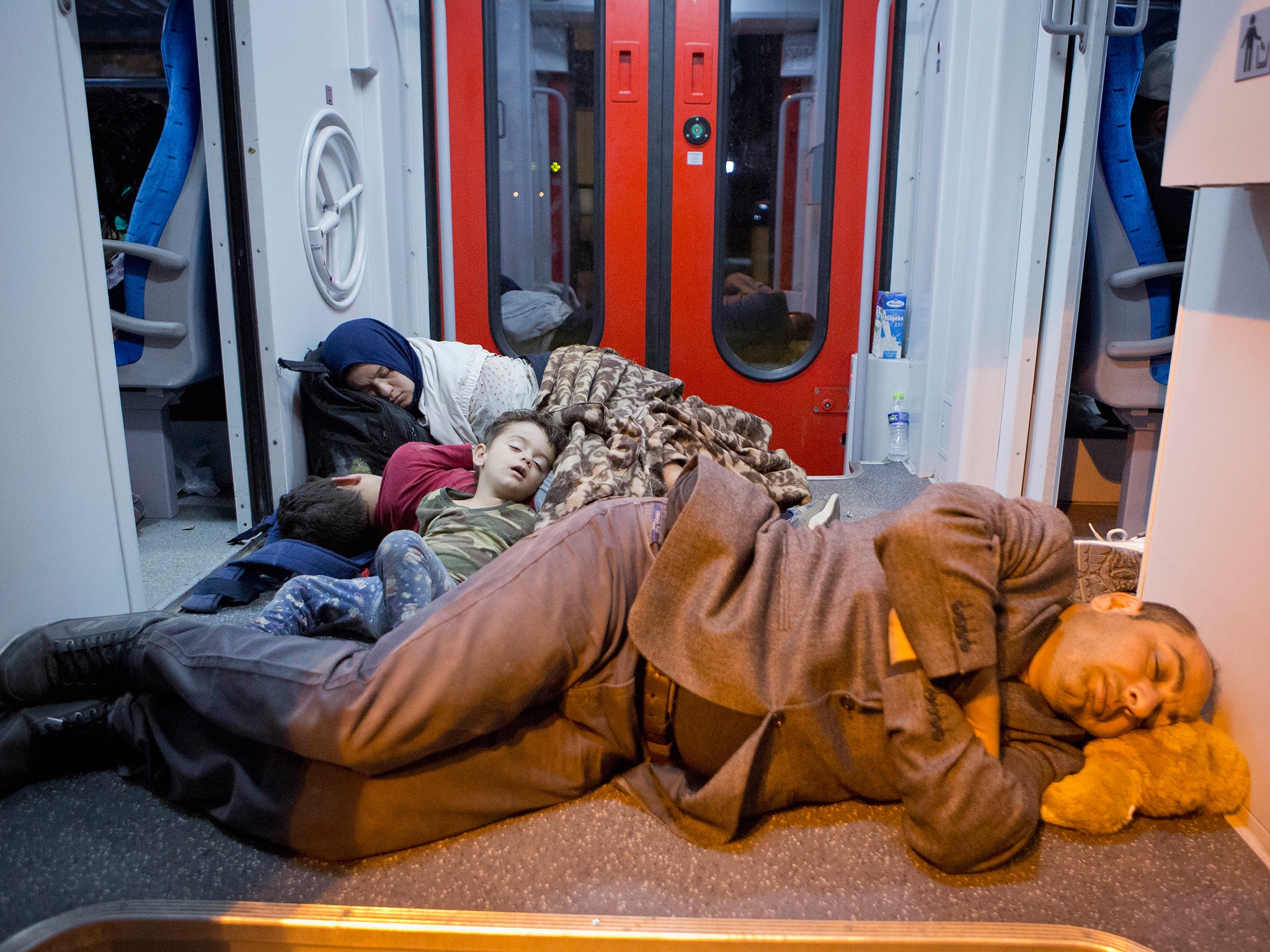Refugees rest in a train at the railway station in Beli Manastir, near the Hungarian border, northeast Croatia, early Friday, Sept. 18, 2015