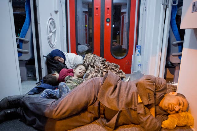 Refugees rest in a train at the railway station in Beli Manastir, near the Hungarian border, northeast Croatia, early Friday, Sept. 18, 2015