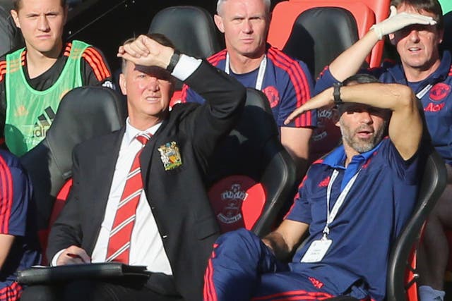 Louis van Gaal and assistant manager Ryan Giggs shield their eyes from the sun
