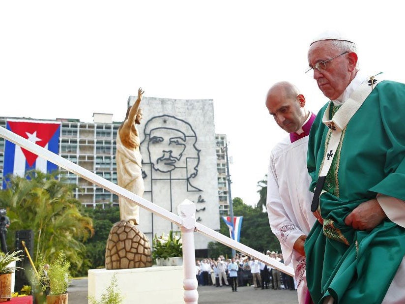 Pope Francis is helped to the altar under the watchful eye of revolutionary Che Guevara in Revolution Square