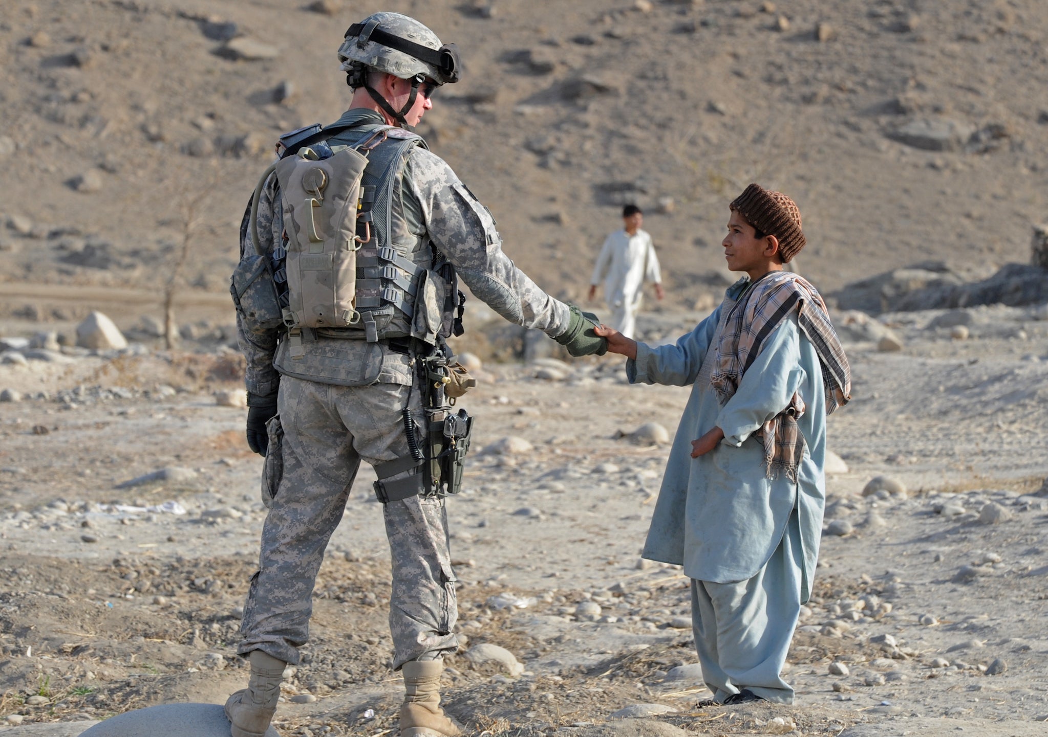 A young child shakes a US soldier's hand in Afghanistan in 2009.