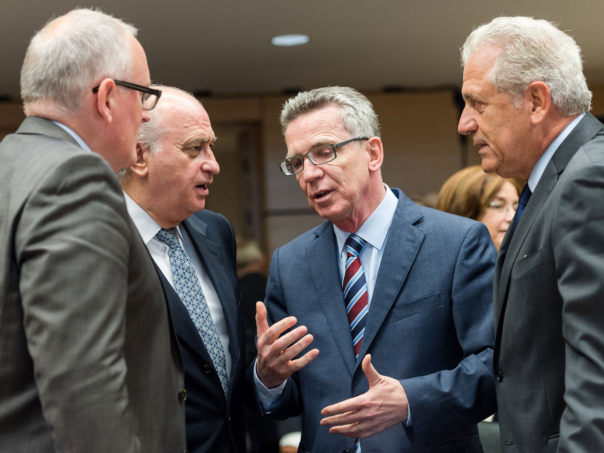 German Interior Minister Thomas de Maiziere, 2nd right, talks with European officials and ministers at the start of a meeting of EU justice and interior ministers at the EU Council building in Brussels on Tuesday