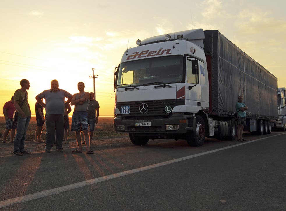 Drivers wait by their lorries at a checkpoint near Ukraine’s border with Crimea on Sunday, where Tatars blocked the border to protest against Russian violations in the annexed region