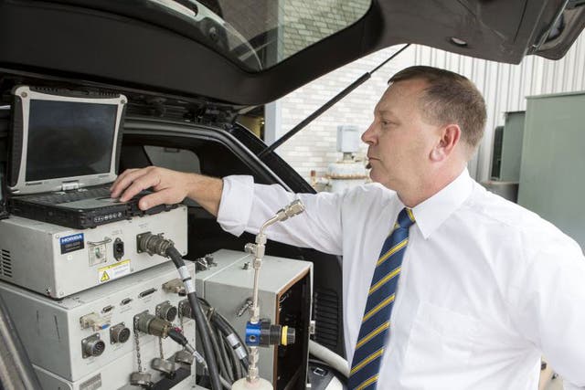 Daniel Carder, the interim director of West Virginia University's Center for Alternative Fuels, Engines and Emissions in Morgantown, West Virginia is shown with a vehicle that has a testing equipment installed, in this undated West Virginia University pho
