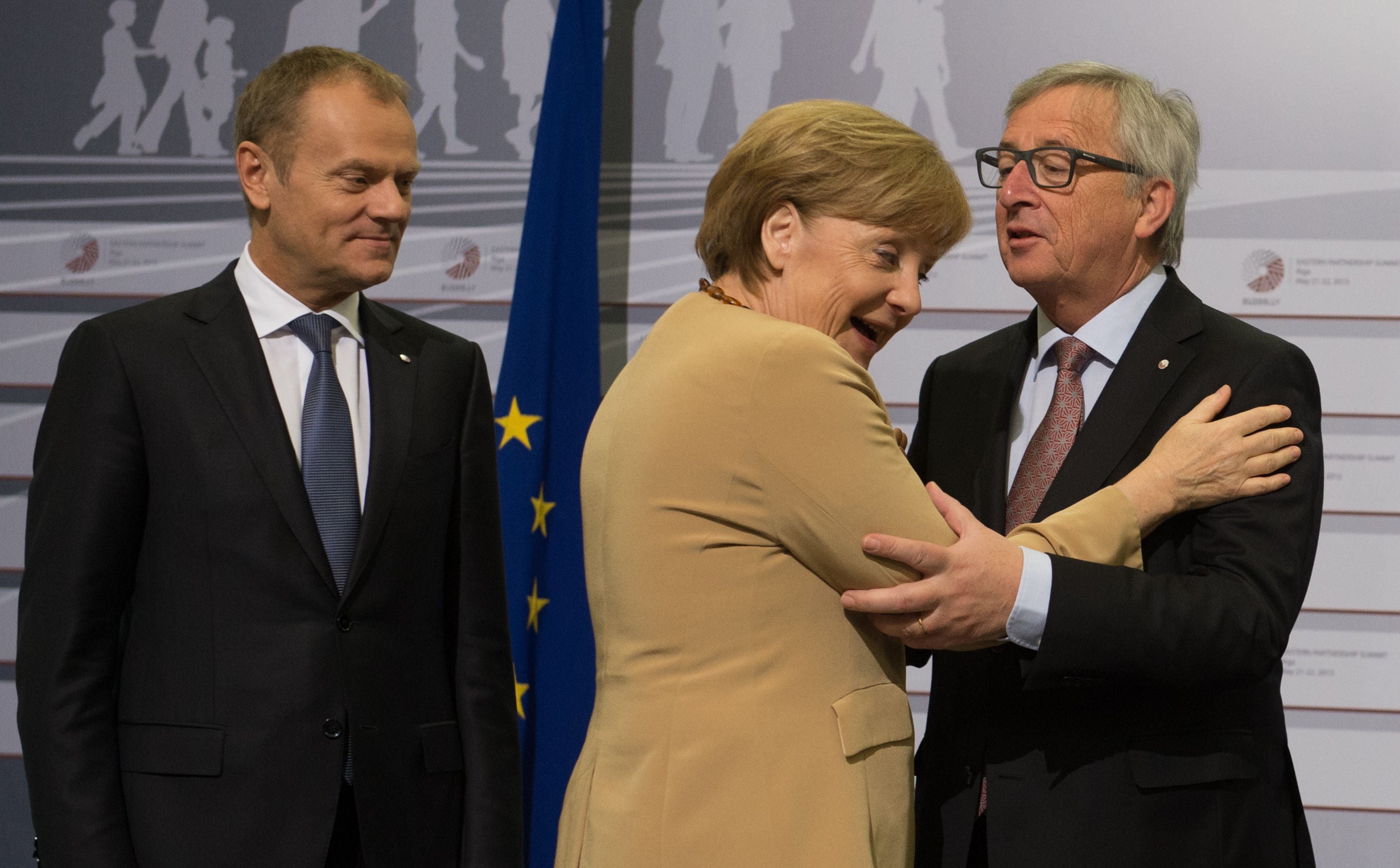 Angela Merkel hugs Jean-Claude Juncker, the EU Commission President, as European Council president Donald Tusk looks on (PA)