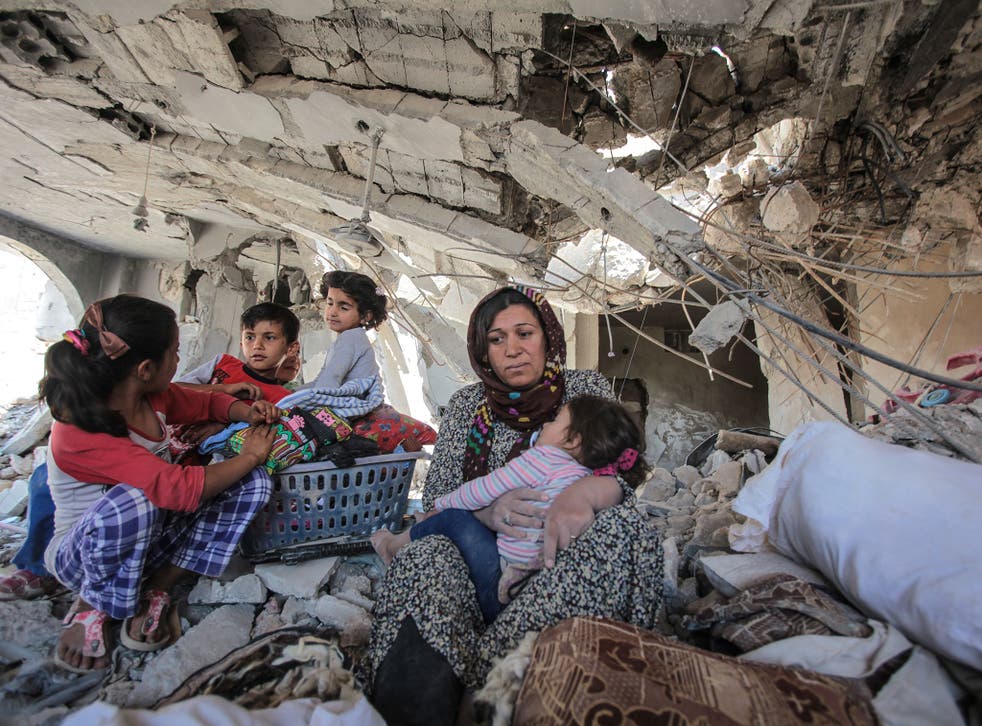A family in their destroyed home in Kobani, where Kurdish YPG forces helped to defeat Isis