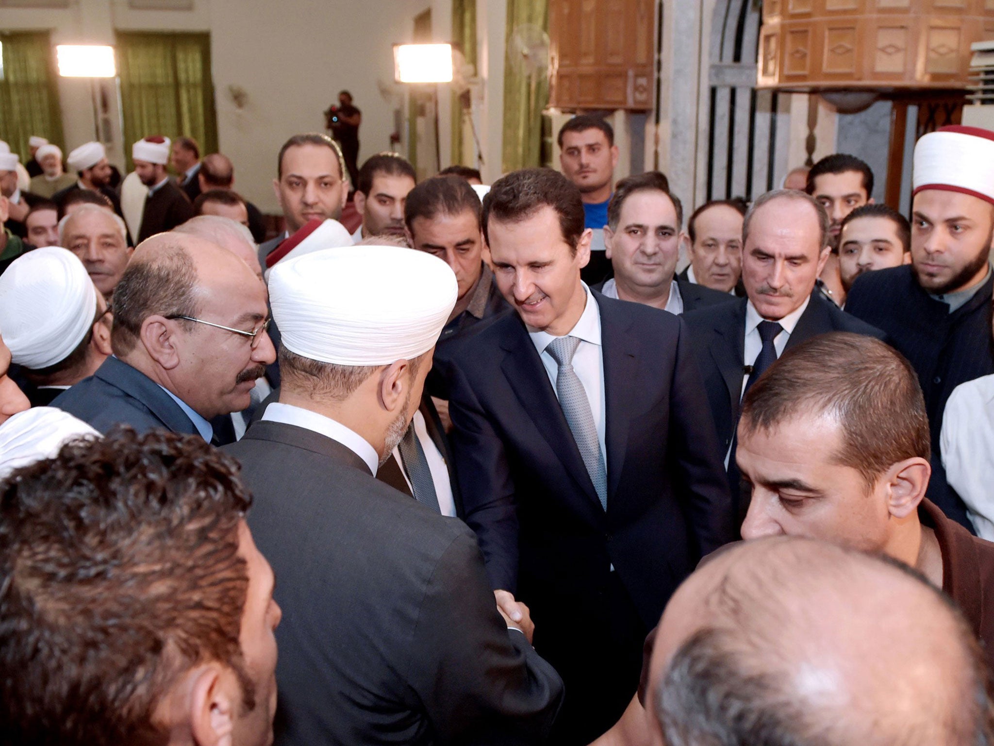 President Assad greets worshippers after the morning prayer to mark the Muslim holiday of Eid al-Adha at the Al-Adel mosque in Damascus, in one of his rare public appearances