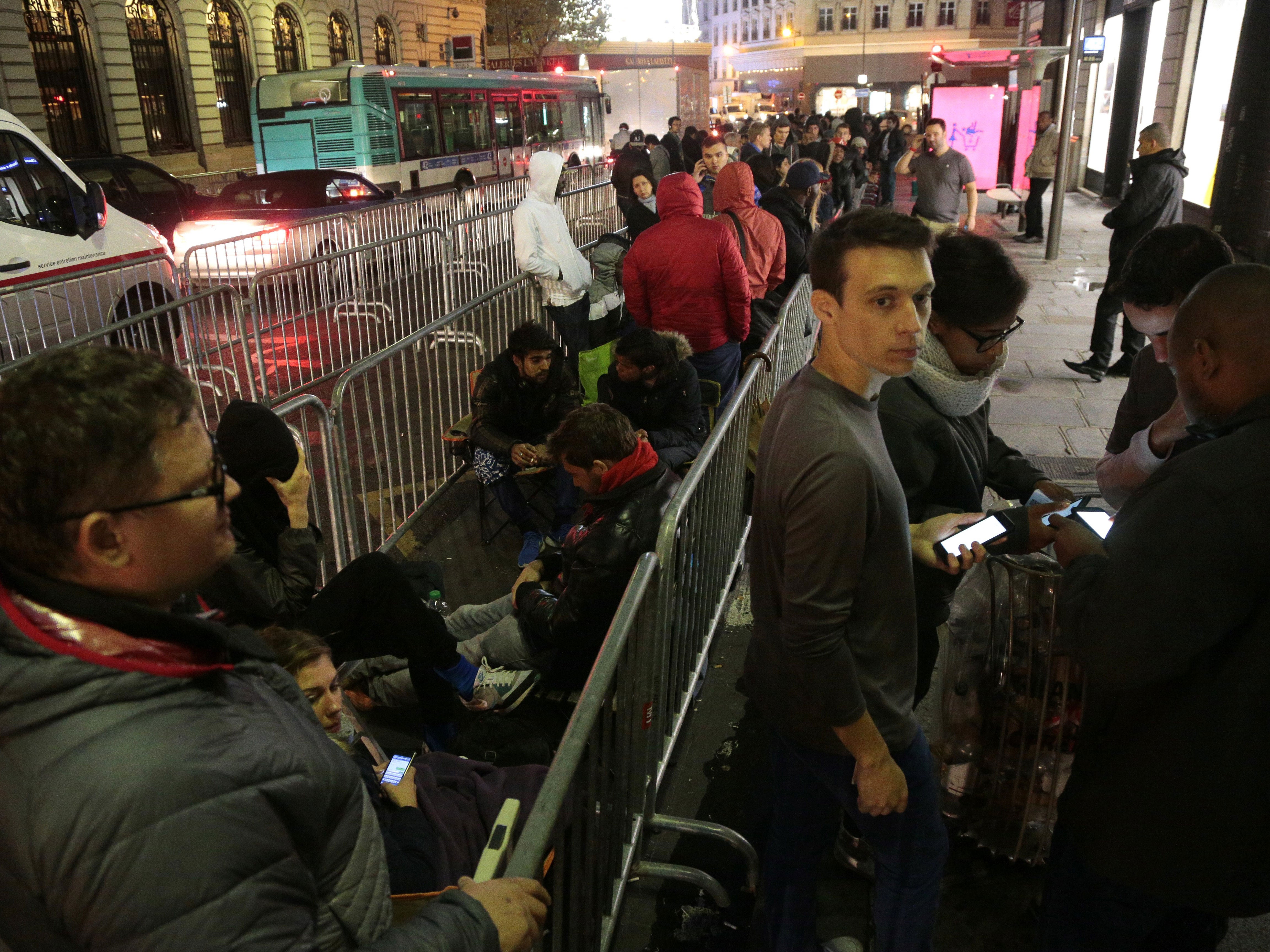 People wait to enter an Apple store on the day of the official launch of the iPhone 6s, on September 25, 2015 in Paris