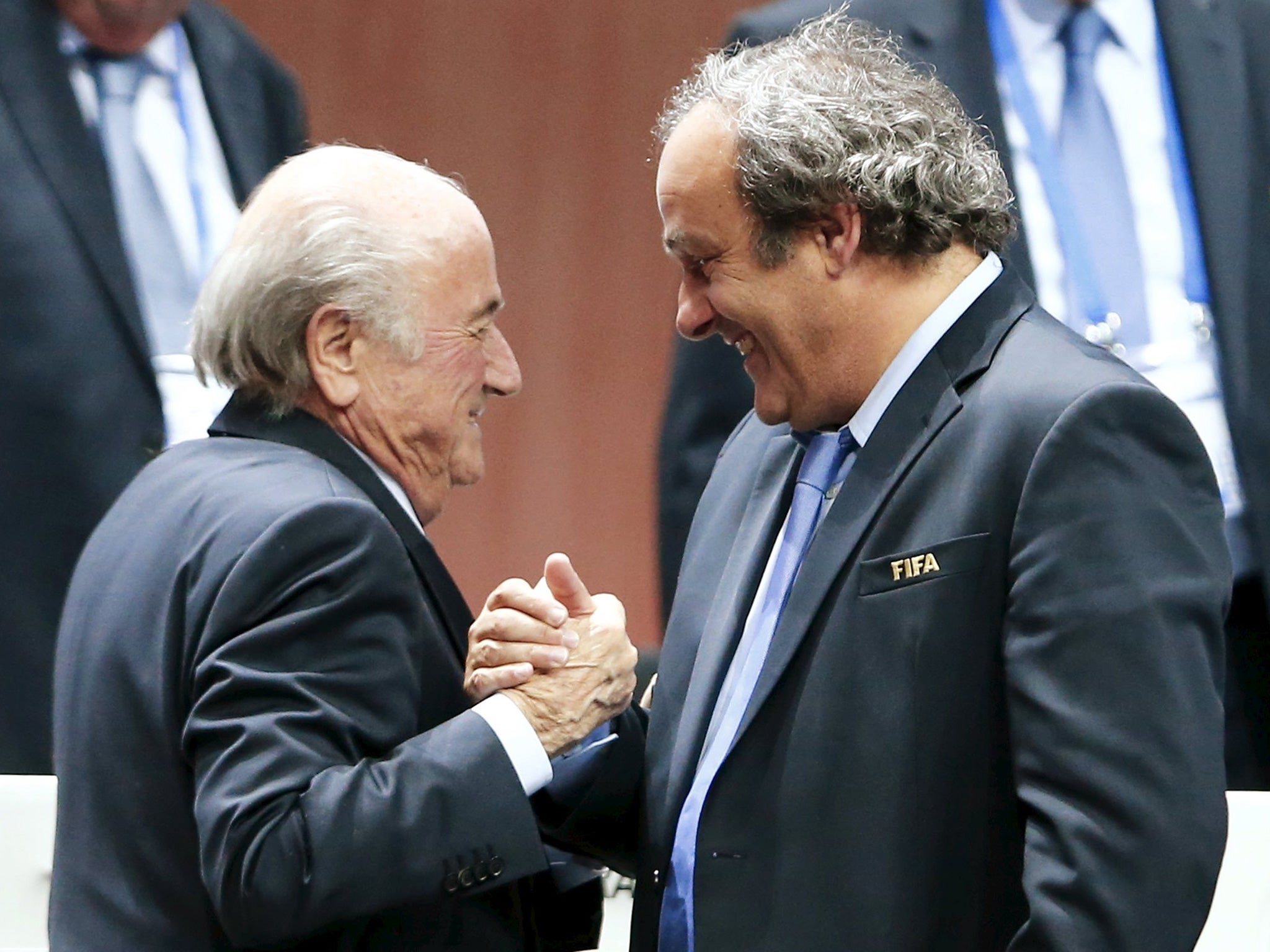 FIFA President Sepp Blatter (Foreground-L) shakes hands with UEFA president Michel Platini after being re-elected following a vote to decide on the FIFA presidency in Zurich on May 29, 2015