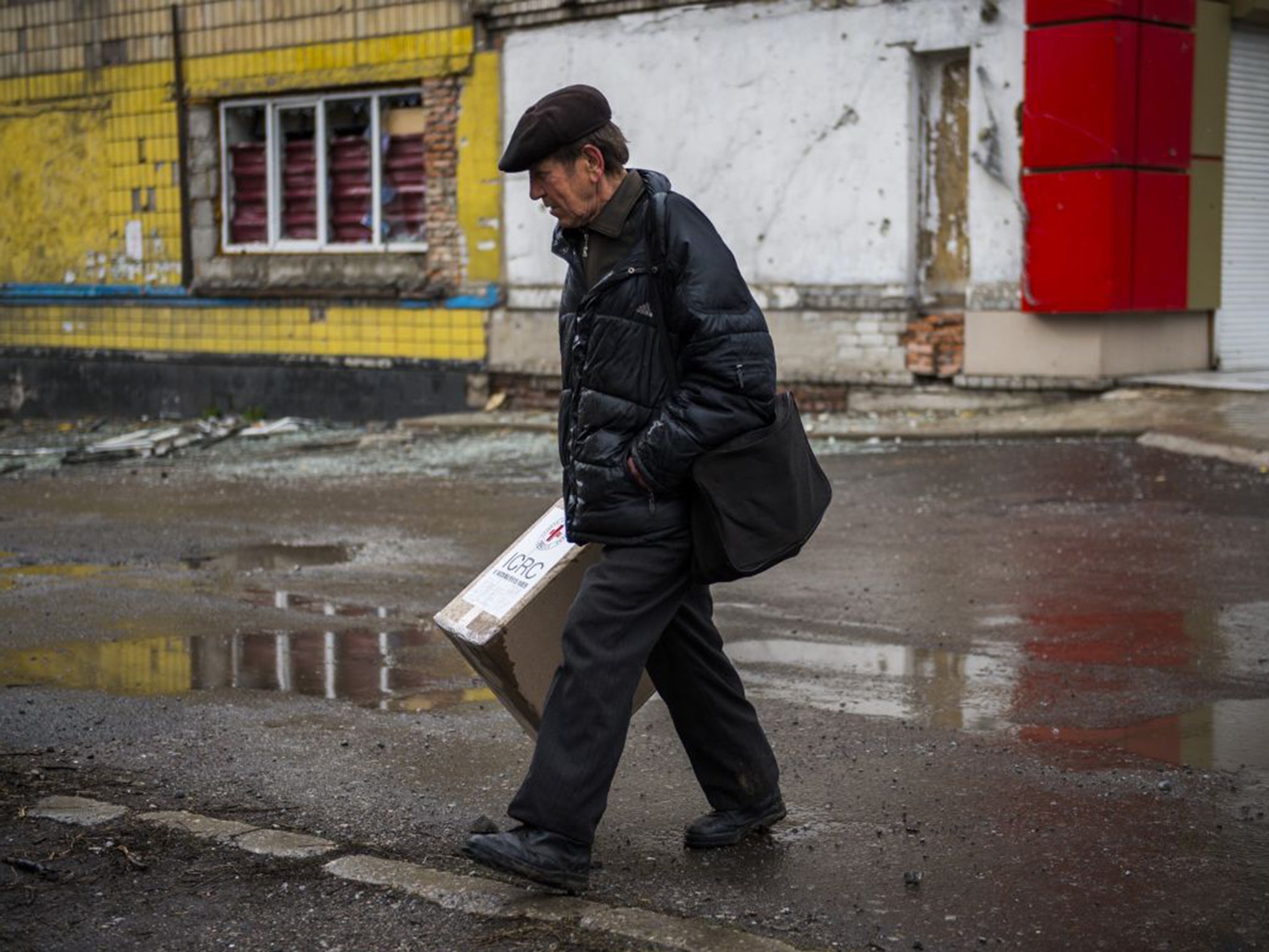 A man carries a Red Cross aid parcel in Debaltseve, Ukraine