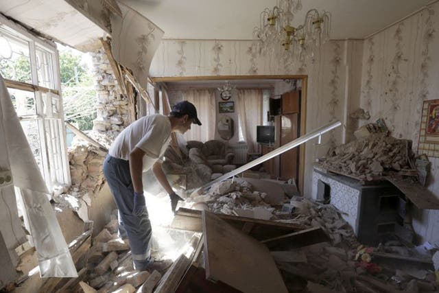A man inspects his shelled home in Donetsk last month