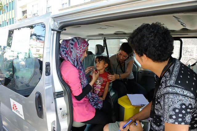 Medical personnel from Médecins Sans Frontières assess the health of a girl, who is accompanied by her mother, in Belgrade, the capital of Serbia