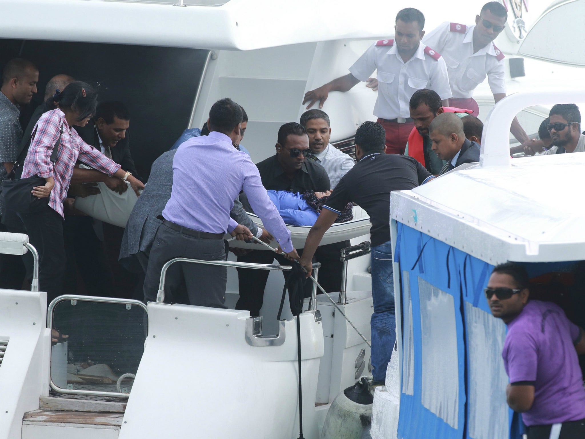Officials carry an injured woman off the speed boat of Maldives President Abdulla Yameen (not pictured) after an explosion onboard, in Male, Maldives