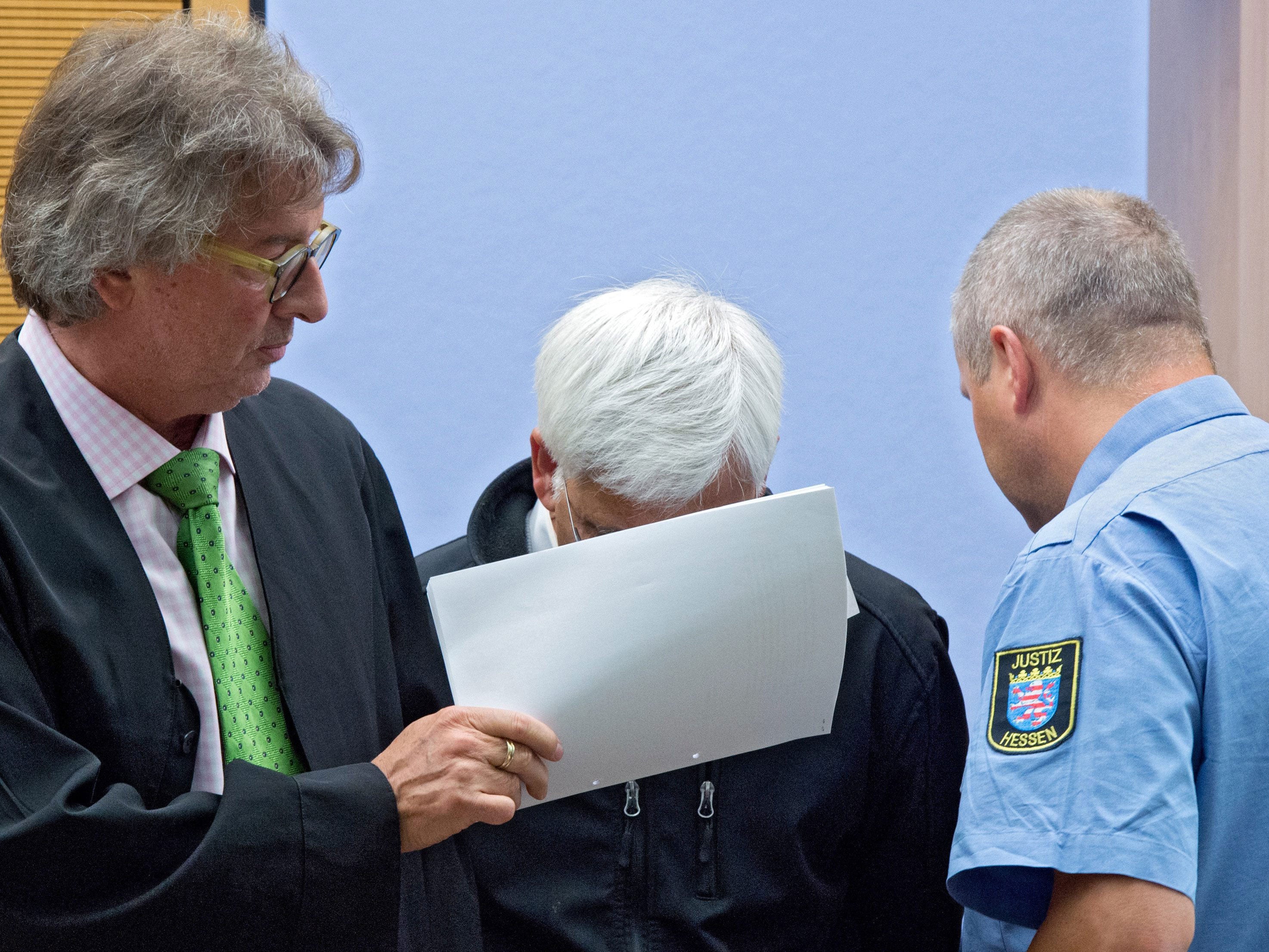 Defendant Asadullah K. (C) is escorted to a courtroom of the regional court in Darmstadt, Germany,