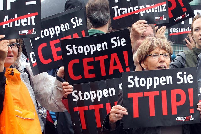 Protestors take part in a demonstration against TTIP and CETA in front of the party headquarters of the Social Democrate Party in Berlin on September 20, 2014
