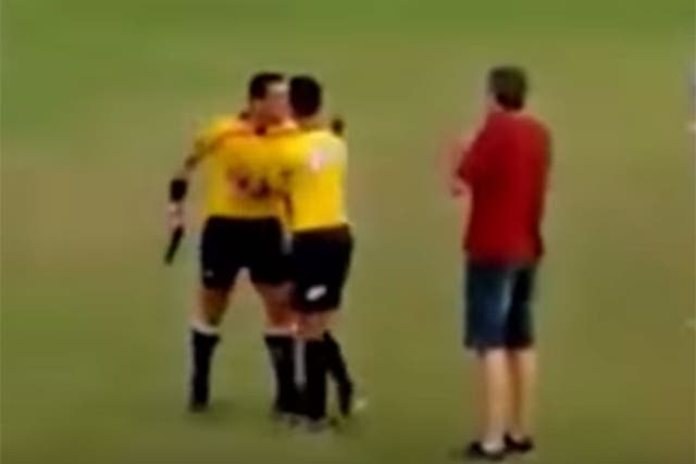 Referee Gabriel Murta pulls a gun during a match