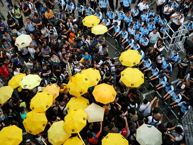 Protesters observe a moment of silence to mark the first anniversary of the ‘Umbrella Movement’ outside the government HQ in Hong Kong