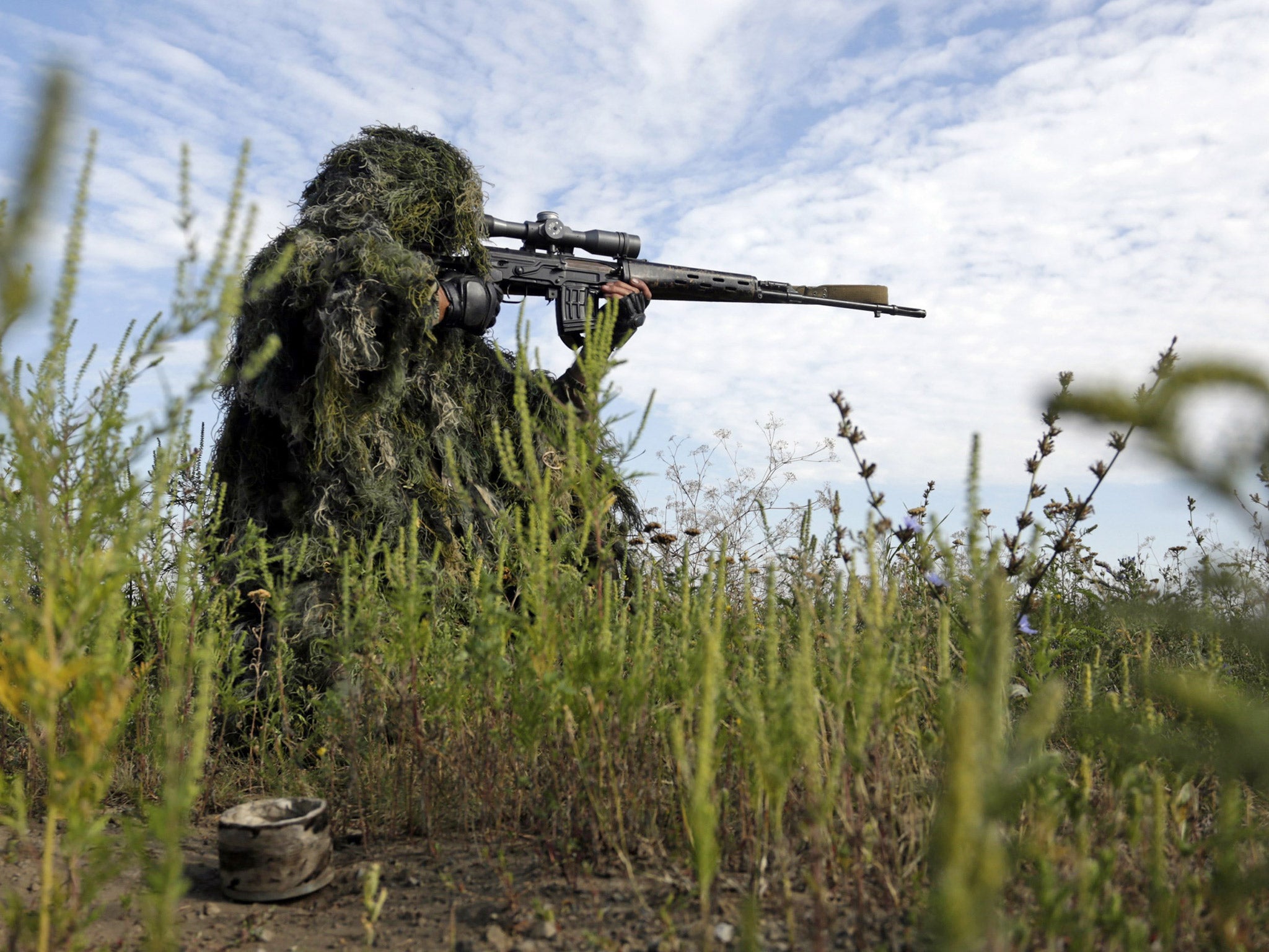 A Ukrainian sniper holds on the position of Ukrainian forces on frontline in Lugansk, last month
