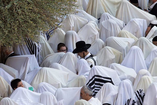 Ultra-Orthodox Jews cover their heads with their prayer shawls and carry the 'four species' during special prayers at the Western Wall, one of Judaism's holiest site