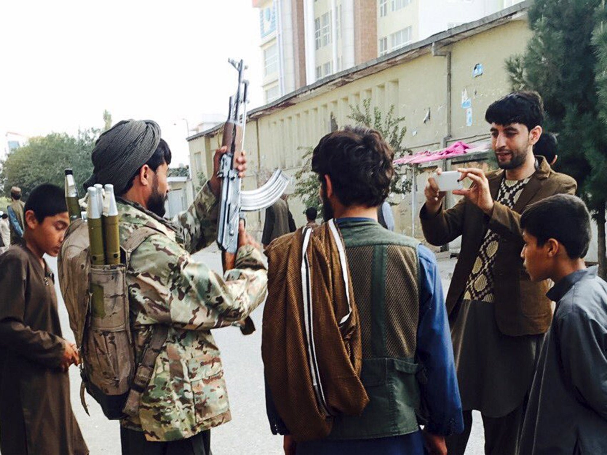 A Taliban fighter poses for a photo in Kunduz’s main square