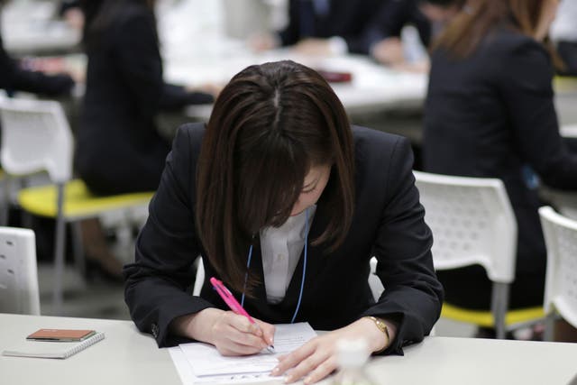 Japanese job-hunting students dressed in suits attend a business manners seminar at a placement centre in Tokyo May 28, 2012.