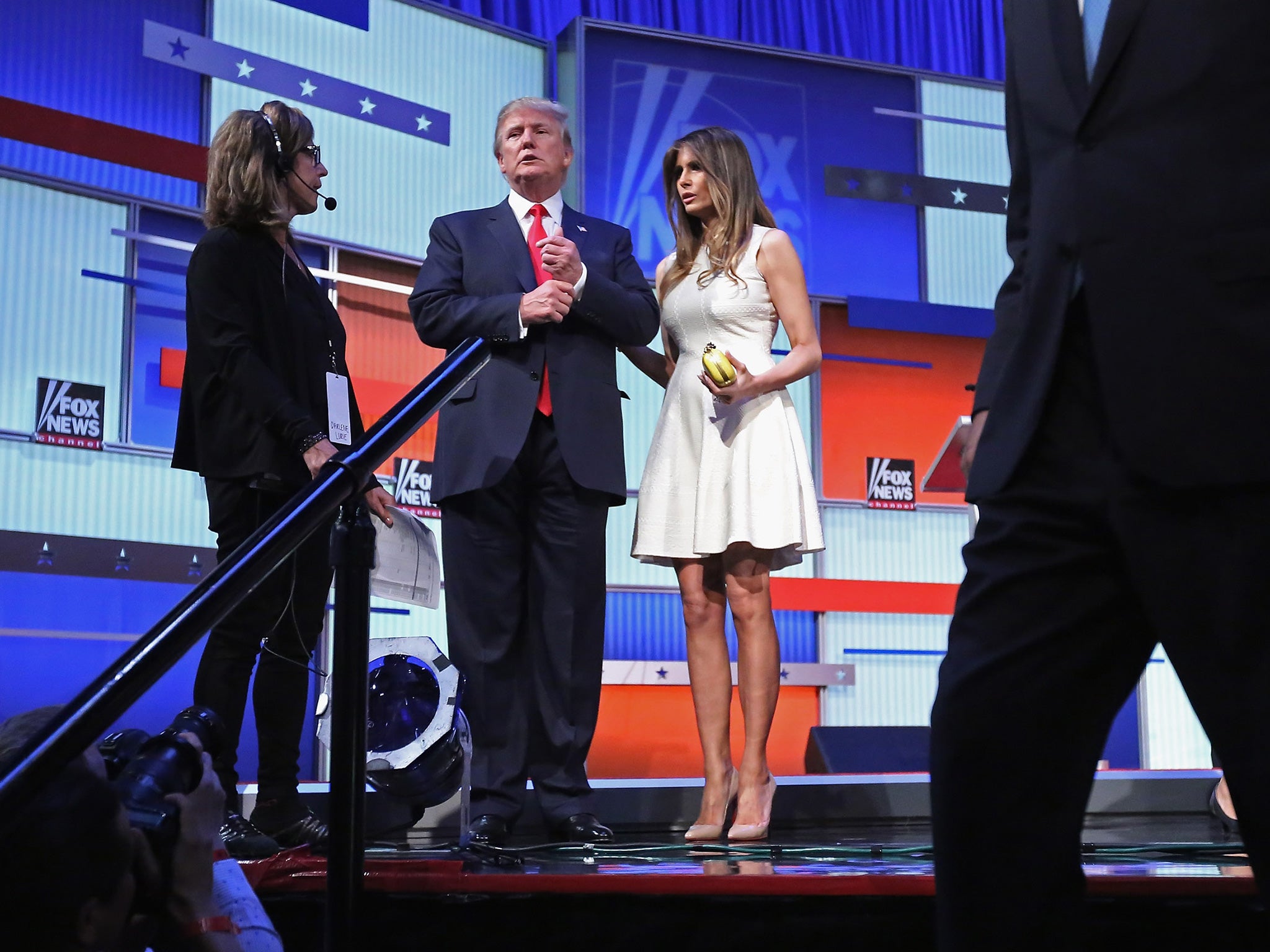 Donald Trump (C) and Melania stand on the stage after the first prime-time presidential debate hosted by FOX News