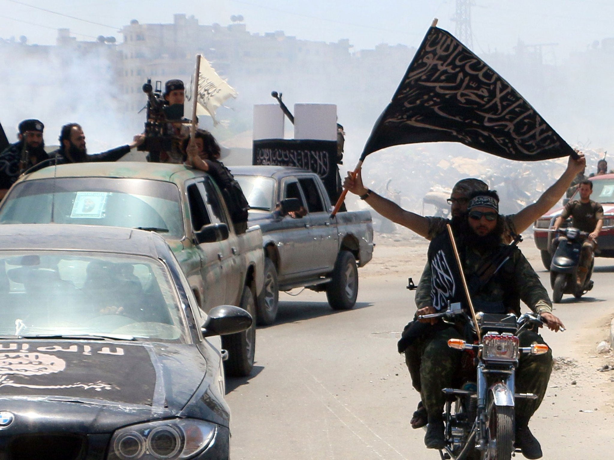 Fighters from Al-Qaeda's Syrian affiliate Al-Nusra Front drive in the northern Syrian city of Aleppo flying Islamist flags as they head to a frontline