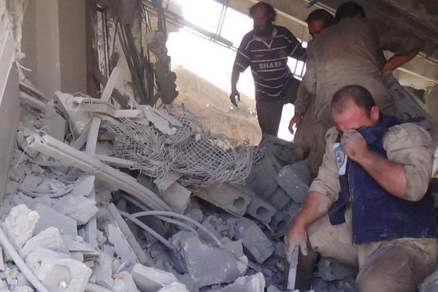 Civil defence workers in the aftermath of the Russian air strike on Talbiseh, Syria, which killed dozens of civilians