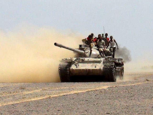 Militants loyal to Yemen's government ride on a tank as they leave to go to the frontline to fight against Houthi militants in control of the Bab al-Mandab Strait