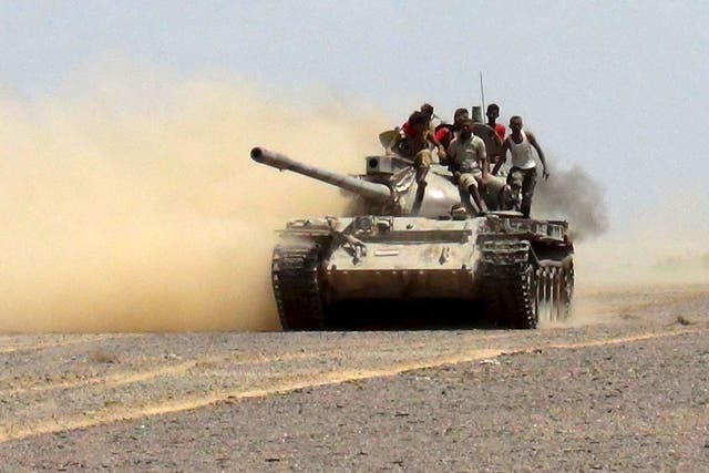 Militants loyal to Yemen's government ride on a tank as they leave to go to the frontline to fight against Houthi militants in control of the Bab al-Mandab Strait