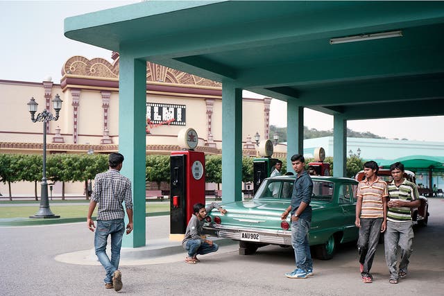 Both car and gas station are part of the film set