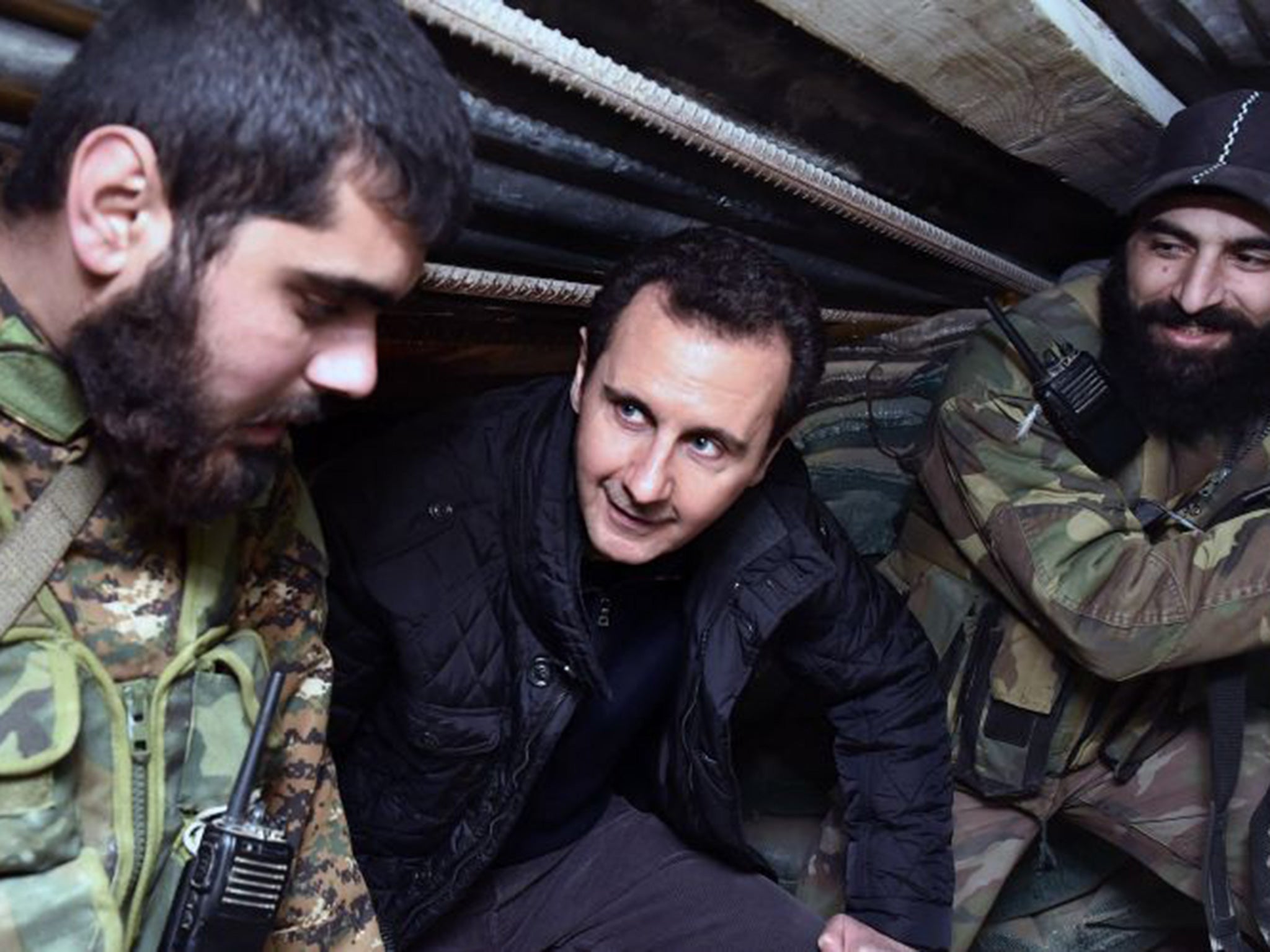 Bashar al-Assad, center, speaks with Syrian troops during his visit to the front line in the eastern Damascus district of Jobar, Syria