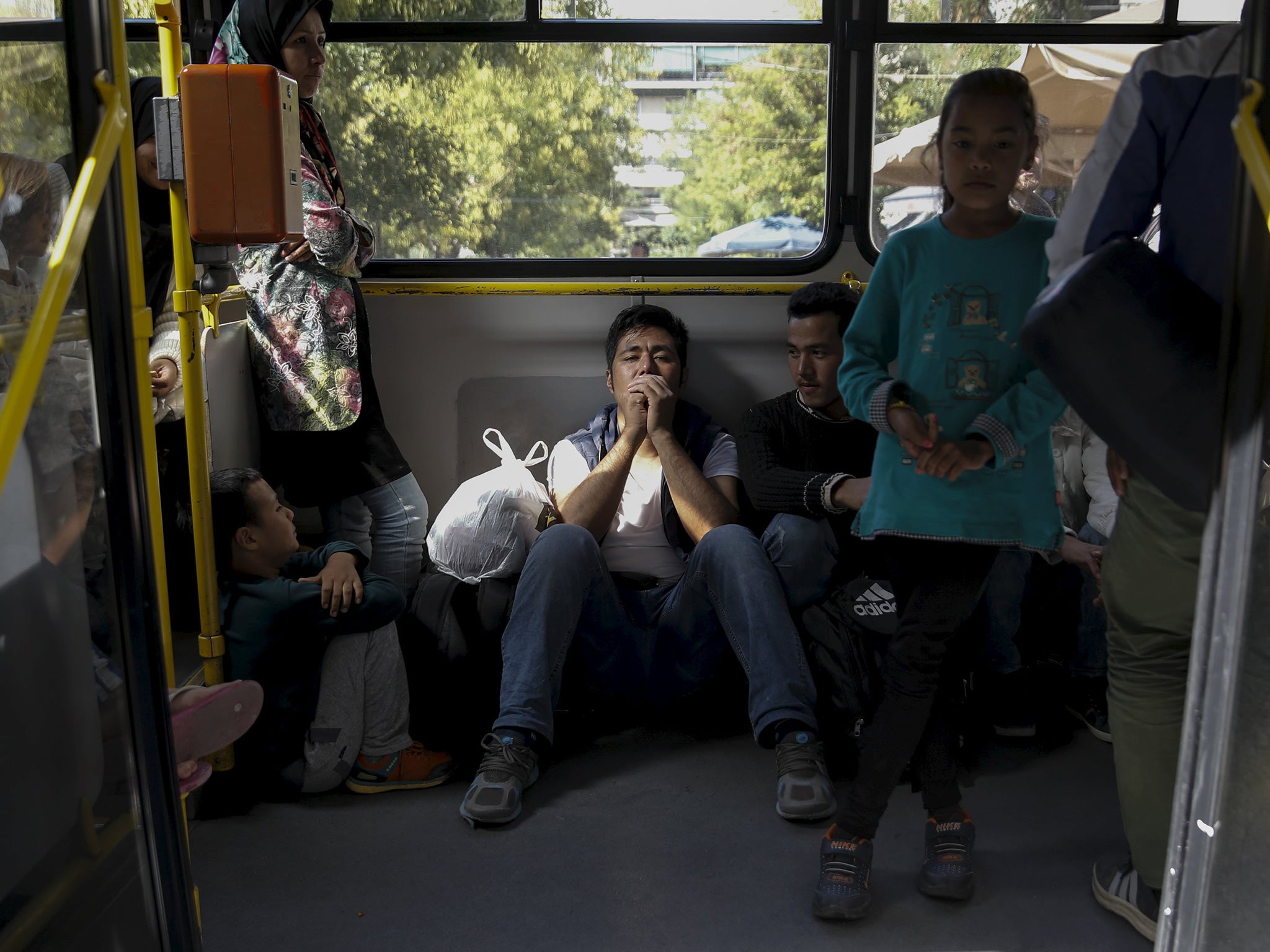 Afghan refugees are on a bus as they are transferred from Victoria Square to Galatis stadium