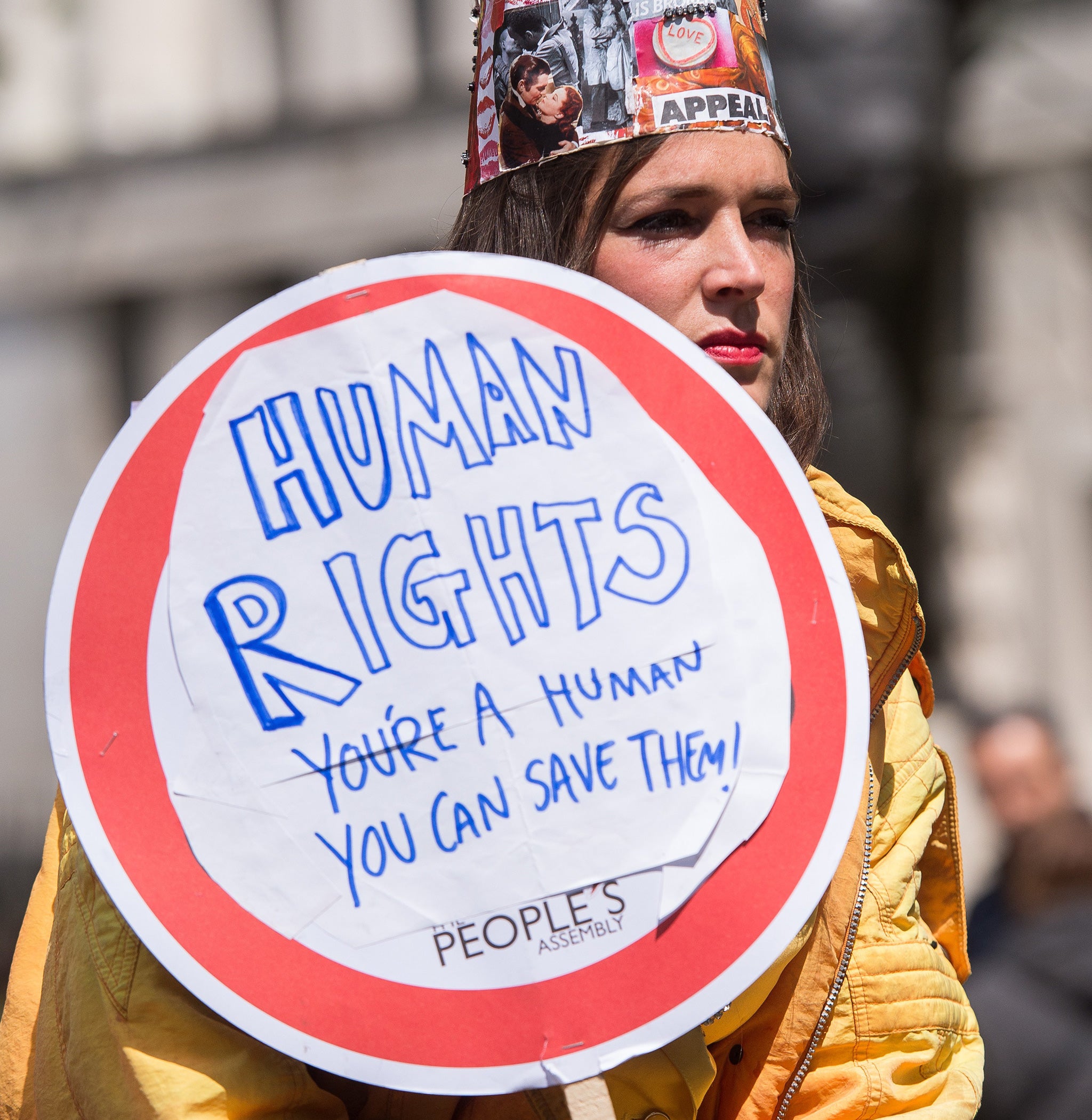A woman wears a decorated crown as she takes part in a human rights protest in central London