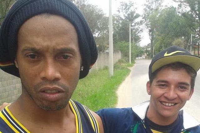 A shaken Ronaldinho poses for a selfie with the fan