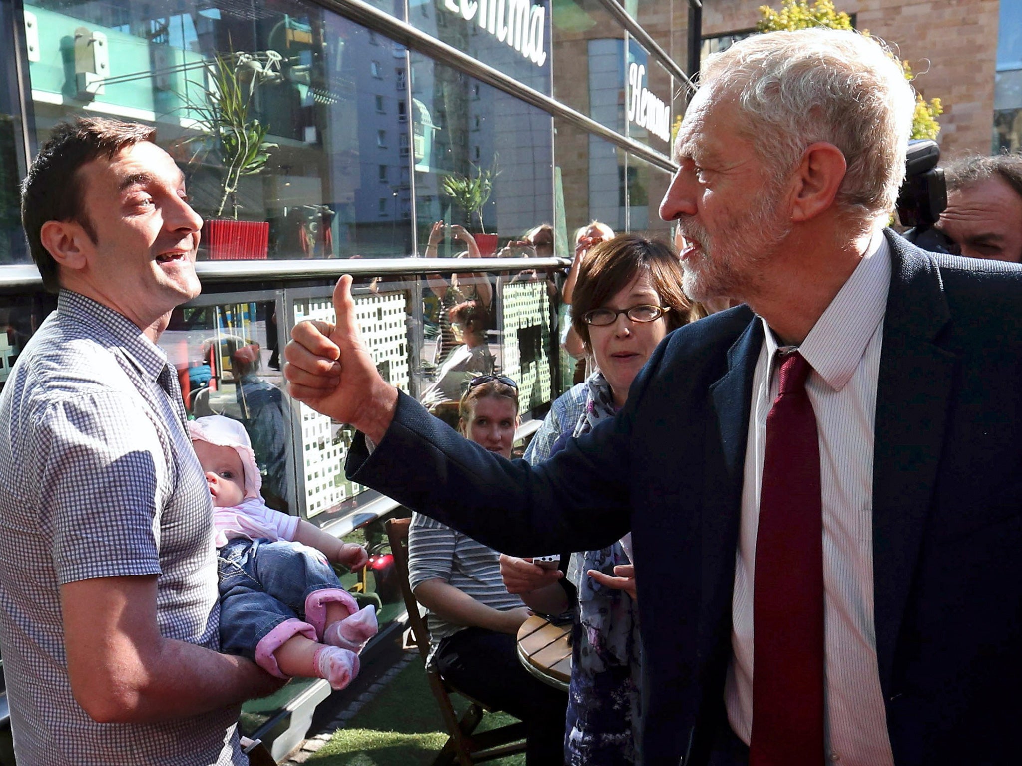 Jeremy Corbyn greets a man holding a baby in Edinburgh, Scotland