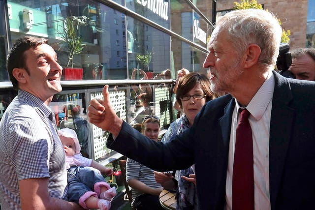 Jeremy Corbyn greets a man holding a baby in Edinburgh, Scotland