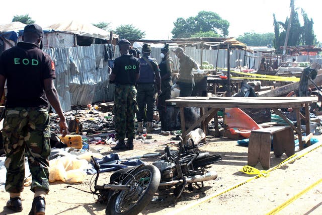 Nigeria security personnel searching the scene of the bomb blast