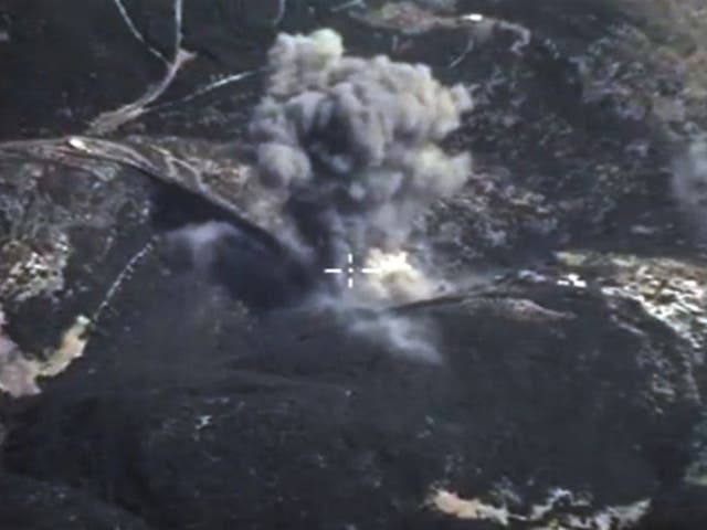 In this photo made from the footage taken from Russian Defense Ministry official web site on Sunday, Oct. 4, 2015, an aerial view of a bomb explosion in Syria