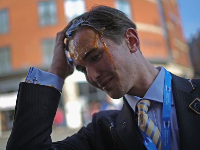 A young Tory delegate is hit by an egg as he arrives for the first day of the Conservative Party Autumn Conference 2015 on October 4, 2015