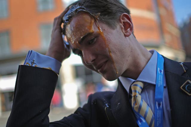 A young Tory delegate is hit by an egg as he arrives for the first day of the Conservative Party Autumn Conference 2015 on October 4, 2015