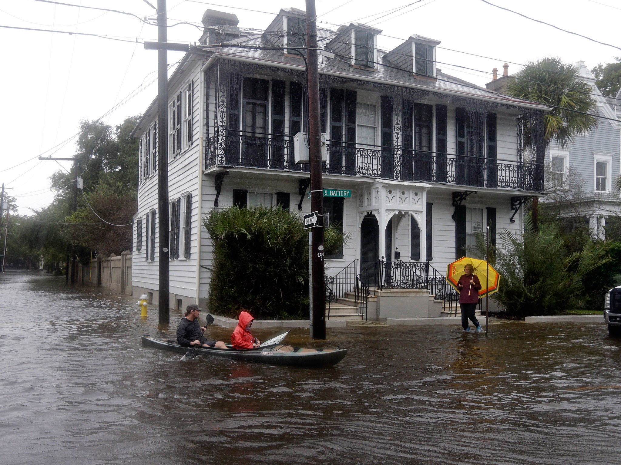 Paul Banker, left, paddles a kayak and his wife Wink Banker, as they takes photos on a flooded street in Charleston, South Carolina
