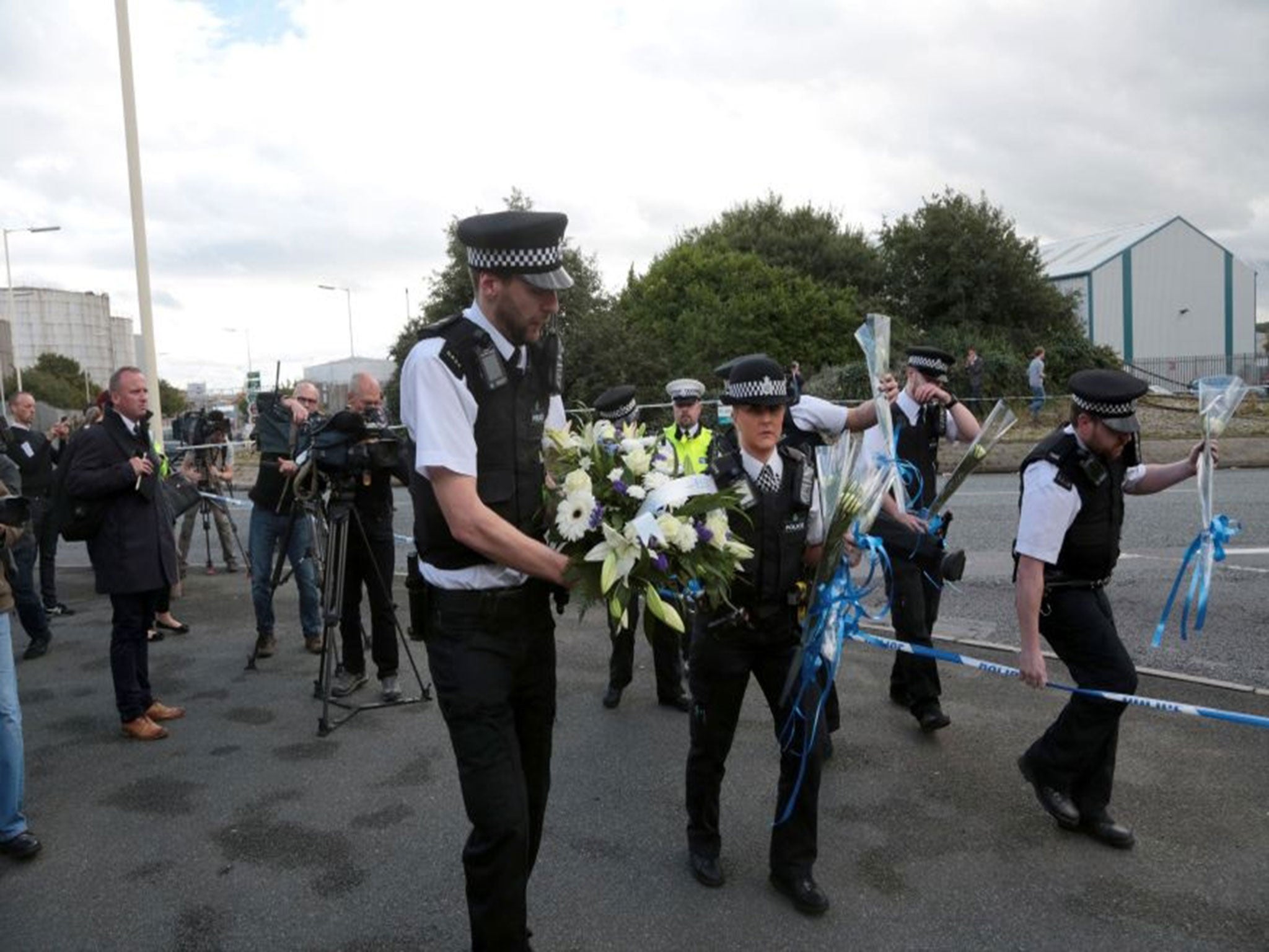 Police officers bring floral tributes to the scene in Wallasey North Road, Wallasey, Merseyside, where Pc David Phillips was mown down and killed by a stolen car.